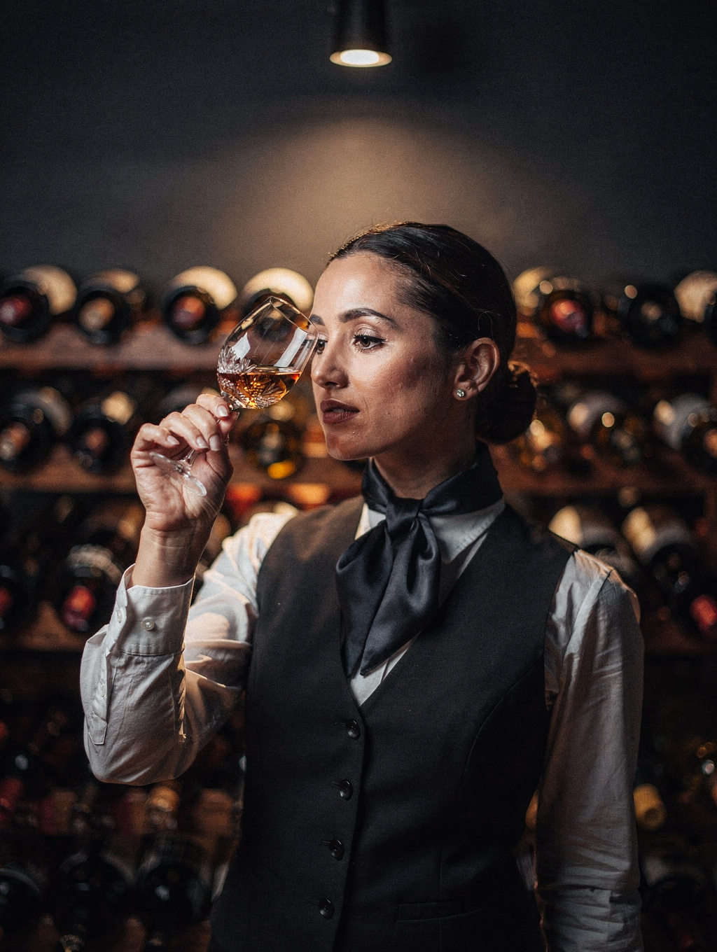 Head Sommelier Elena Bianchi selecting a vintage bottle in the cellar